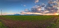 Atmospheric landscape featuring a cloudy sky casting a dramatic shadow over a vast field of crops