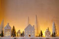Atmospheric miniature christmas village. Stylish little white houses and trees on snow blanket with glowing lights in evening. Royalty Free Stock Photo