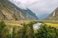 Atmospheric mountain landscape on a cloudy foggy day in the valley of Chulyshman. The river runs in a green valley Royalty Free Stock Photo