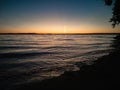 Atmospheric phenomenon sun column.Sunset over the lake. Evening summer landscape. Horizontal photo