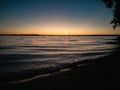 Atmospheric phenomenon sun column.Sunset over the lake. Evening summer landscape. Horizontal photo