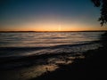 Atmospheric phenomenon sun column.Sunset over the lake. Evening summer landscape. Horizontal photo