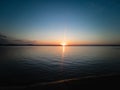 Atmospheric phenomenon sun column.Sunset over the lake. Evening summer landscape. Horizontal photo