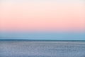 Atmospheric romantic pink red sea sunset sky above blue quiet water, minimalistic peaceful seascape Royalty Free Stock Photo