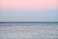 Atmospheric romantic pink red sea sunset sky above blue quiet water, minimalistic peaceful seascape