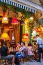 Atmospheric scene of people sitting at an Athens cafeteria late