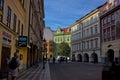 An atmospheric street in the old district of Prague is lined with buildings with colorful facades.