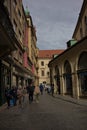 An atmospheric street in the old district of Prague is lined with buildings with colorful facades.