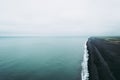 Atmospheric view from Dyrholaey lightouse cliff over the black sand beach.