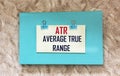 ATR Average True Range, green diary on a beige background, business concept