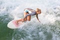 Atractive sporty girl surfing on famous artificial river wave in Englischer garten, Munich, Germany.