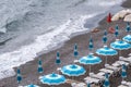 Rows of blue and white parasols and sunbeds on the beach at Atrani on the Amalfi Coast, Italy.