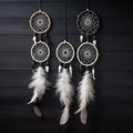 3 attache dWhite dream catcher with feather hanging at black wooden background