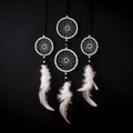3 attache dWhite dream catcher with feather hanging at black wooden background