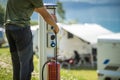 Attaching Camper RV Power Cable to Camping Electric Post During Camping Stay Royalty Free Stock Photo