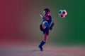 Teen male football or soccer player, boy on gradient background in neon light - motion, action, activity concept Royalty Free Stock Photo