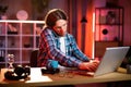 Attactive satisfied smiling young caucasian man in checkered shirt talking on phone and typing on laptop, Royalty Free Stock Photo