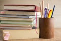 Attainment of knowledge: a pile of books with bookmarks, glasses and pencils in a pencil stand