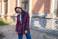 Attaractive brunette girl in glasses dressed in plaid jacket and white shirt bowed her head on left shoulder and looking Royalty Free Stock Photo