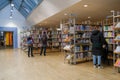 A group browsing books in library shelves filled with publications Royalty Free Stock Photo