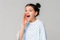 Attention, announcement. Side view of dark-haired teen girl in oversized t shirt holding arm near wide open mouth and screaming Royalty Free Stock Photo