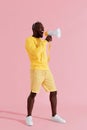 Attention! Black man shouting in megaphone on pink background