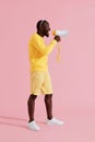 Attention! Black man shouting in megaphone on pink background