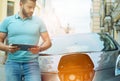 Attentive young man looking at his electric car Royalty Free Stock Photo