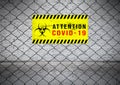 Attention coronavirus covid 19 and outbreak alert sign on Wire fence. Old white brick wall background Royalty Free Stock Photo