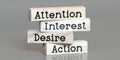 Attention, interest, desire, action - words on wooden blocks