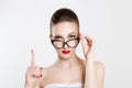 Attention listen to me. Close up portrait young woman wagging her finger holding glasses skeptically isolated white grey wall Royalty Free Stock Photo