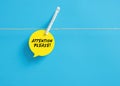 Attention please message on a speech bubble hanging on clothesline with a clothespin Royalty Free Stock Photo