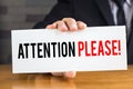 Attention please, message on white card and hold by businessman Royalty Free Stock Photo