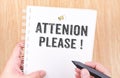 Attention please! word on white ring binder notebook with hand h Royalty Free Stock Photo