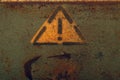 Attention sign in yellow triangle on rusty metal background. exclamation symbol Royalty Free Stock Photo