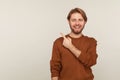 Attention to advertising! Portrait of happy handsome bearded man pointing to side copy space and smiling Royalty Free Stock Photo