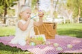 Attentive Baby Girl Coloring Easter Eggs on Picnic Blanket