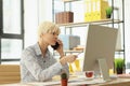 Attentive blonde worker listens to client on phone at work