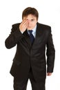 Attentive businessman closed eyes with his hand