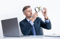 attentive businessman investigating plant through magnifying glass in business office Royalty Free Stock Photo