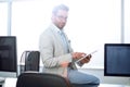 Attentive businessman uses a digital tablet in a modern office. Royalty Free Stock Photo