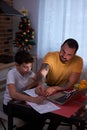 Attentive and careful father help son to study