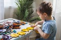 Attentive cute baby boy learning geometric figure shapes playing multicolored wooden construction Royalty Free Stock Photo