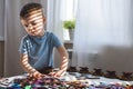 Attentive cute baby boy learning geometric figure shapes playing multicolored wooden construction Royalty Free Stock Photo