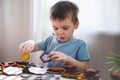 Attentive cute baby boy learning geometric figure shapes playing multicolored wooden construction Royalty Free Stock Photo