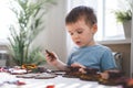 Attentive cute baby boy learning geometric figure shapes playing multicolored wooden construction Royalty Free Stock Photo