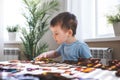 Attentive cute baby boy learning geometric figure shapes playing multicolored wooden construction Royalty Free Stock Photo