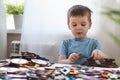 Attentive cute baby boy learning geometric figure shapes playing multicolored wooden construction Royalty Free Stock Photo