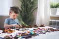 Attentive cute baby boy learning geometric figure shapes playing multicolored wooden construction Royalty Free Stock Photo