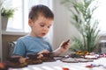 Attentive cute baby boy learning geometric figure shapes playing multicolored wooden construction Royalty Free Stock Photo